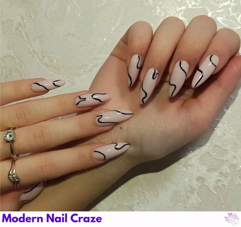 Black and nude split almond nails with bold contrast for an edge.