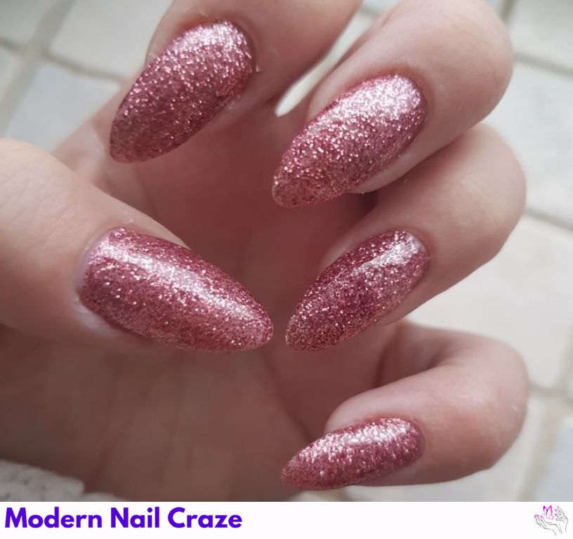 Glitter bomb almond nails coated entirely in silver and gold sparkles.