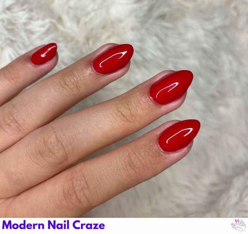 Short red almond nails in crimson shade with a shiny top coat