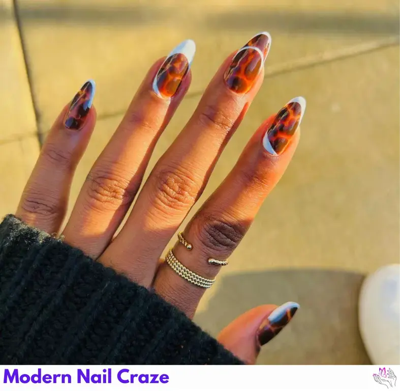 Abstract tortoiseshell nails featuring a mix of animal prints and white polish, for a chic and versatile look.