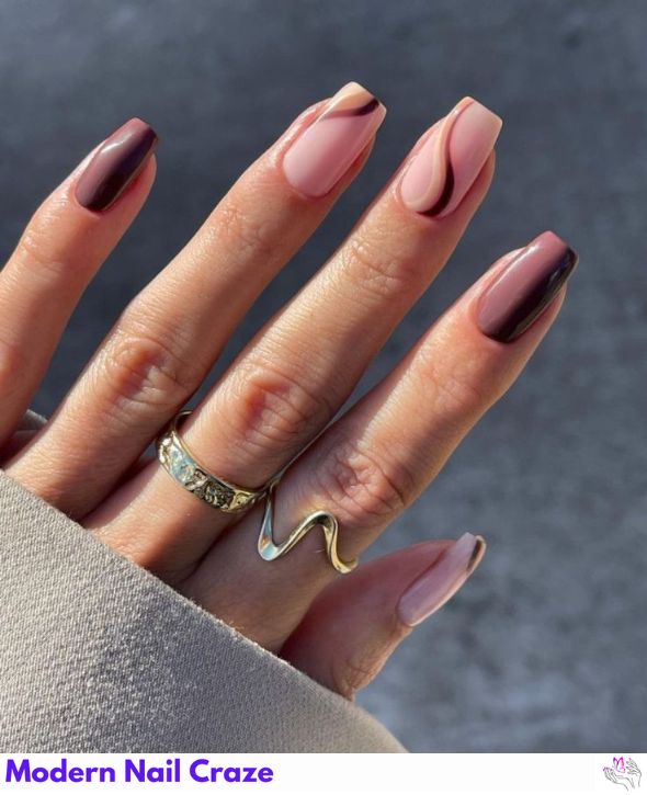 Neutral nails with elegant brown swirl accents.