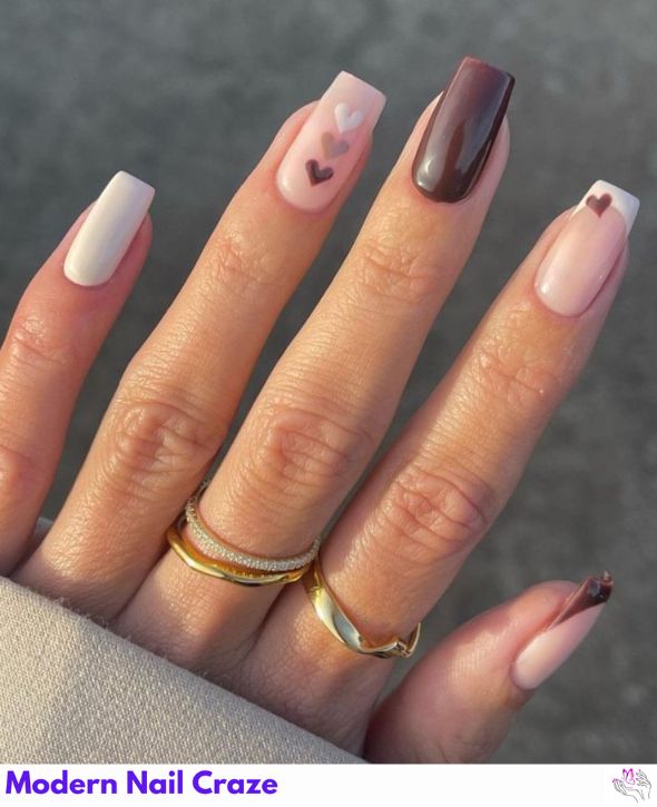 Nude nails with cute chocolate brown heart accents.
