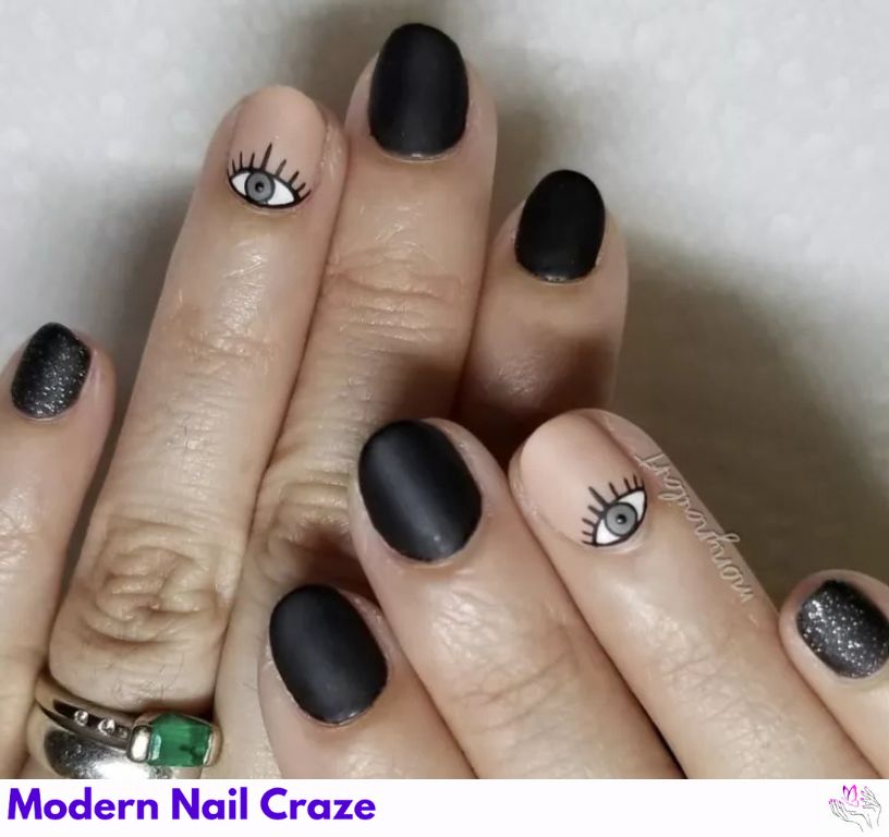Dainty matte black nails with design with eye accents.