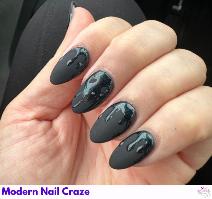 Bold matte black nails with design on almond-shaped nails.
