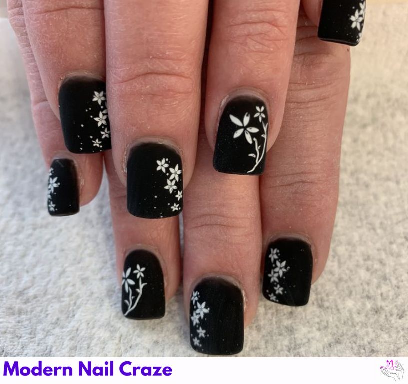 Nature-inspired matte black nails with design for vacations.