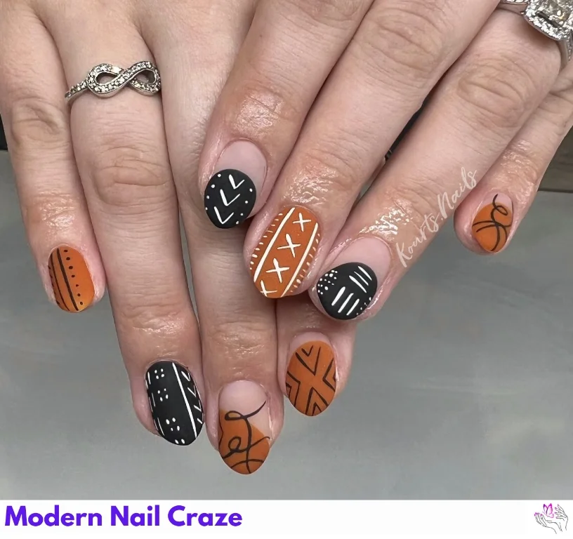 Black and burnt orange patterned nails with spiderweb and lace motifs for fall.