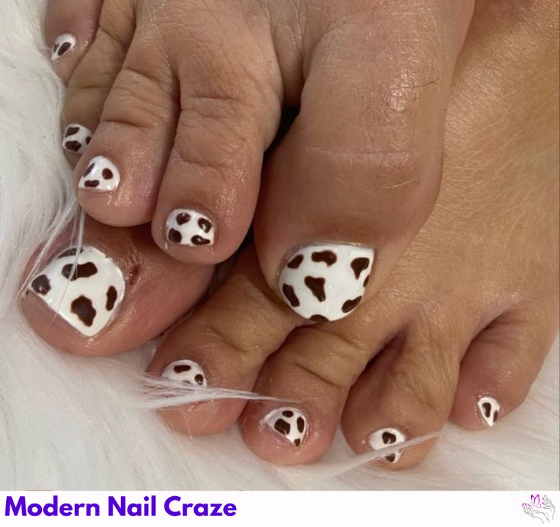 Cow print design on toenails in black and white contrast.
