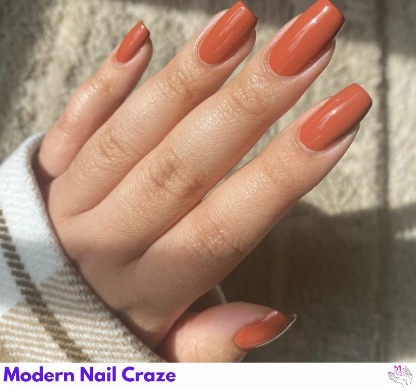 Elegant glossy solid burnt orange nails on medium oval tips.