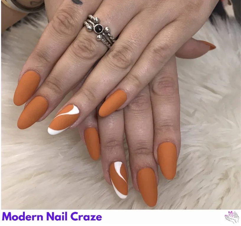 Almond-shaped burnt orange nails with sleek white stripe detailing — minimal fall nail art.
