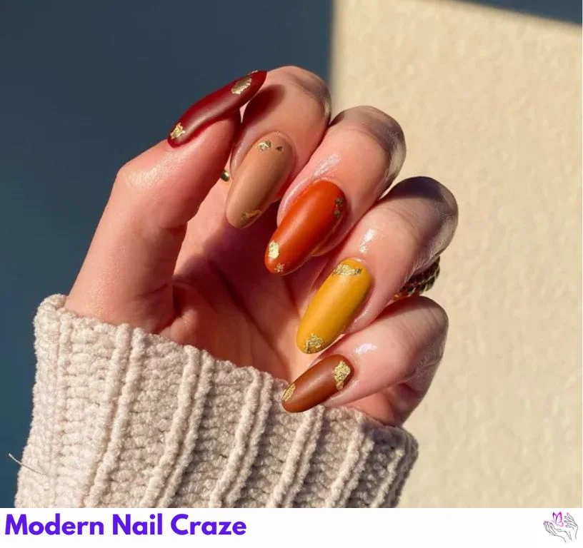 Gilded gradient nails fading from burnt orange to gold glitter.