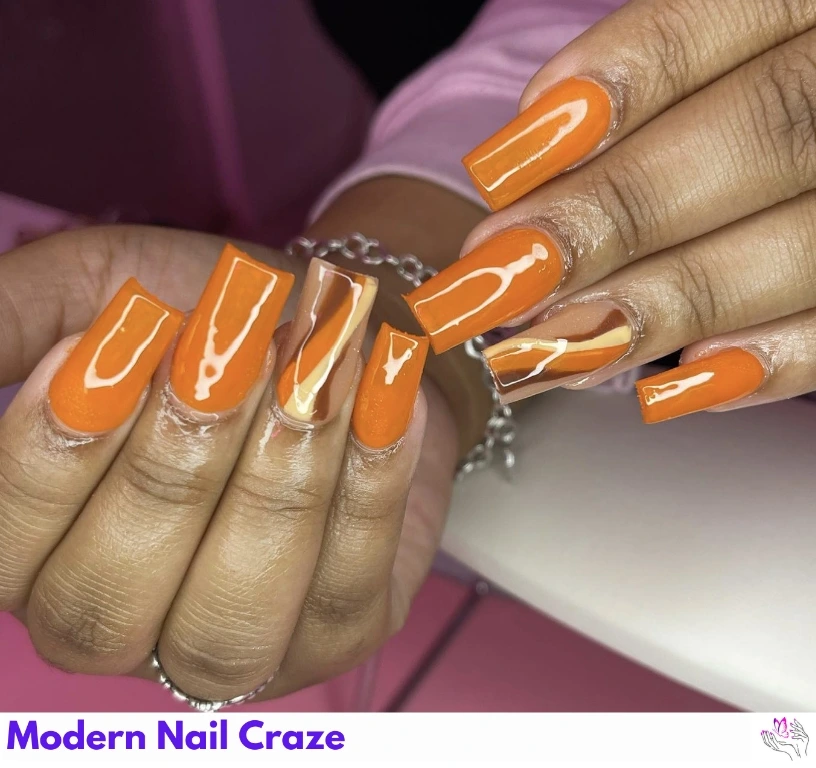 Glossy burnt orange square nails with flowy metallic accent lines.