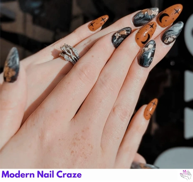 Marble and celestial-themed burnt orange nails with star and moon details.