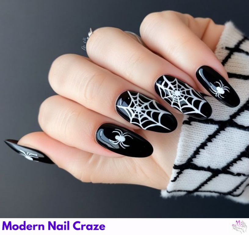 Hand with long almond-shaped nails painted with orange polish and black spider web art for Halloween 2025.