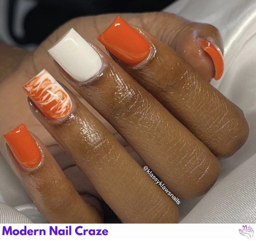 Dual-tone fall manicure with white and burnt orange polish on short nails.