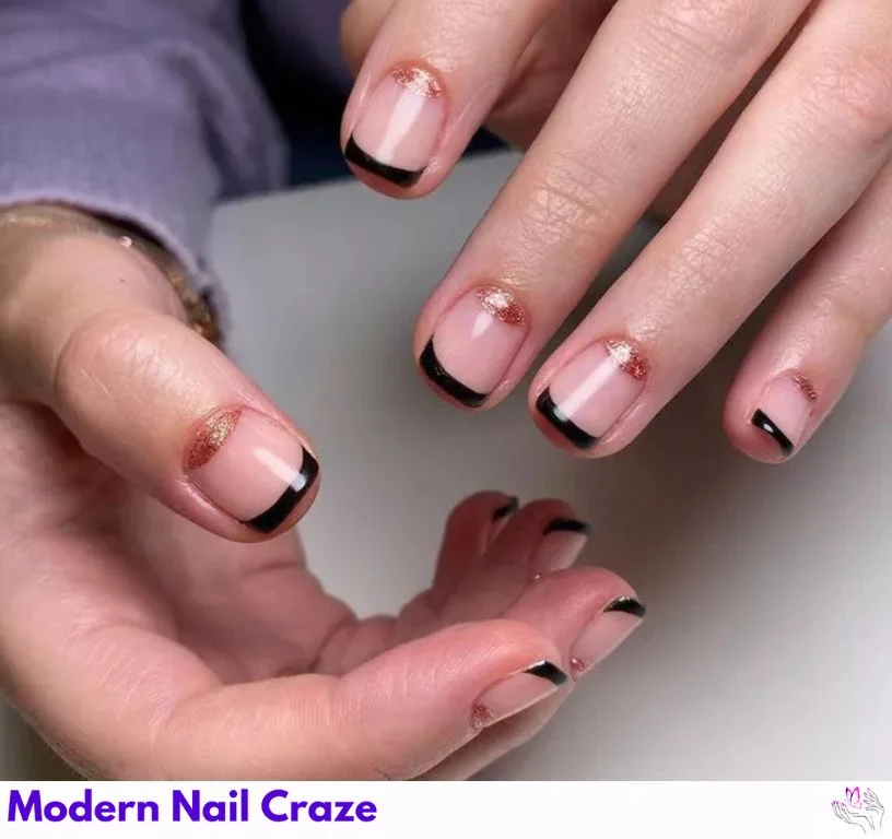 Black French manicure with gold sparkle half-moon nail design at the cuticle